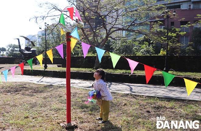 A little girl enjoying the game of throwing a ball.