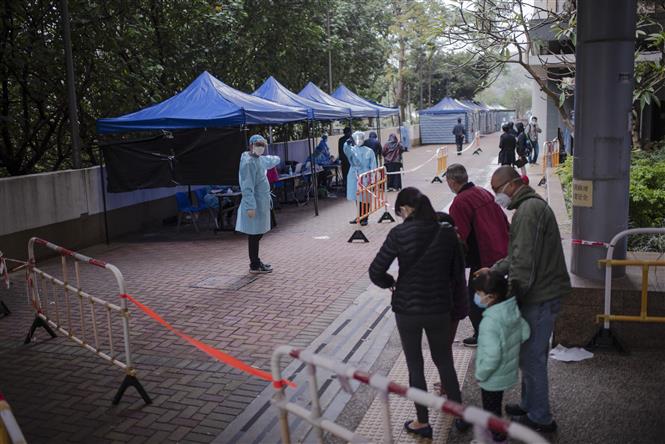 Người dân đợi xét nghiệm COVID-19 sau khi tòa nhà chung cư bị phong tỏa tại Hong Kong, Trung Quốc, ngày 22/1/2022. Ảnh: AFP/TTXVN