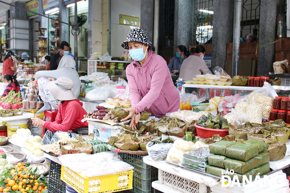 A stallholder in the Han Market is seen rearranging offerings for sale to see off ‘Ong Cong Ong Tao’. Photo: THANH TINH