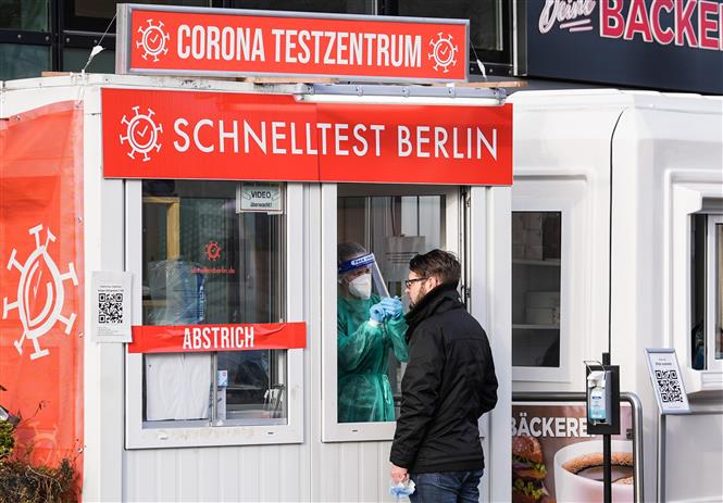  Nhân viên y tế lấy mẫu xét nghiệm Covid-19 cho người dân tại Berlin, Đức, ngày 19-1-2022. Ảnh: THX/TTXVN