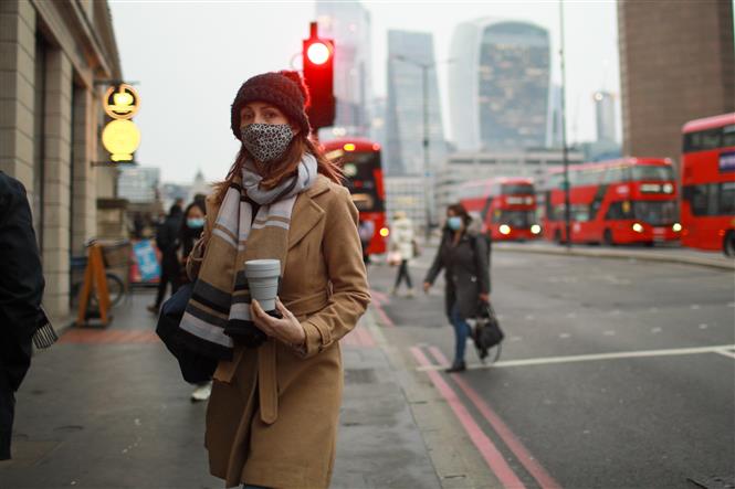 Người dân đeo khẩu trang phòng dịch Covid-19 khi đi trên đường phố thủ đô London, Anh ngày 24-1-2022. Ảnh: THX/TTXVN