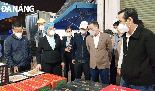 Phó Chủ tịch UBND thành phố Ngô Thị Kim Yến (thứ 2, trái sang) kiểm tra công tác bảo đảm an toàn giao thông tại chợ đầu mối Hòa Cường rạng sáng 25-1.  Ảnh: PHAN CHUNG.