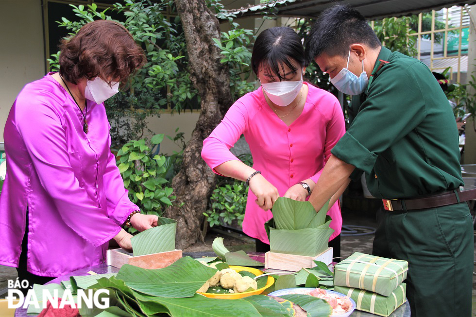 The wrapping of 'banh chung' is done meticulously.