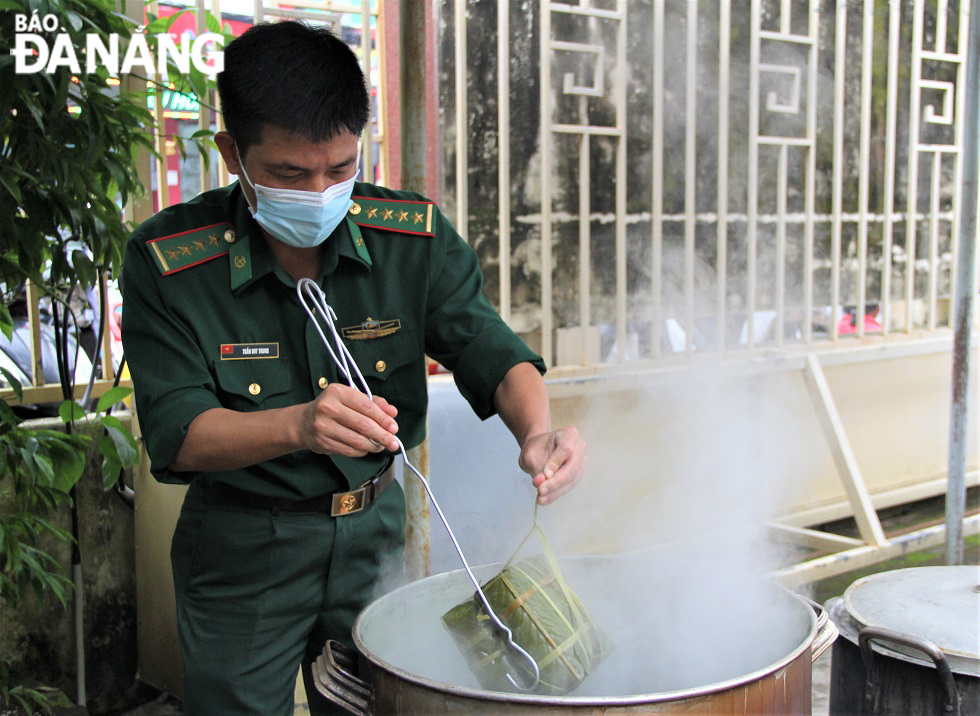 A border guard soldier taking a ‘banh chung’ out of the pot.