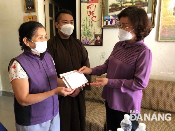 Vice Chairwoman of the Da Nang People's Committee Ngo Thi Kim Yen giving a cash gift to support disadvanatged children in Hoa Minh Ward, Lien Chieu District, whose fathers have died of COVID-19. Photo: NGOC DOAN 