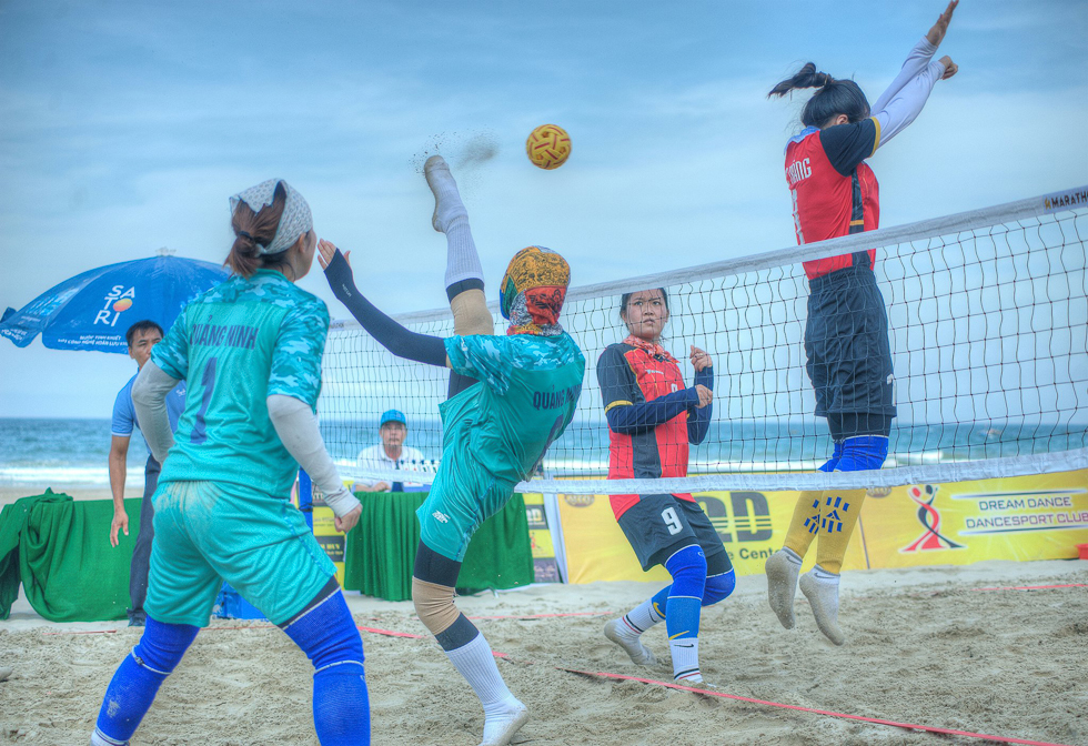 Young people playing a rattan ball on beach