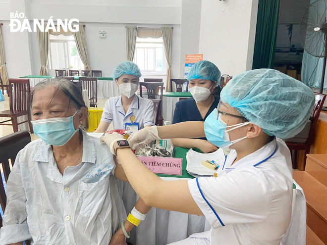 Da Nang C Hospital staffer administers the first dose of COVID-19 vaccine for an elderly in-patient. Photo: D.H.L