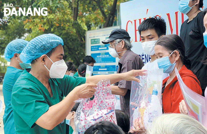 Bác sĩ Nguyễn Đại Vĩnh, Giám đốc Trung tâm Y tế huyện Hòa Vang (trái) tặng quà cho các bệnh nhân điều trị khỏi Covid-19.  