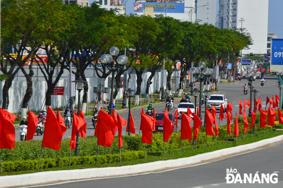 A row of brilliant red flags on the median strip of Vo Van Kiet Street in Son Tra District.