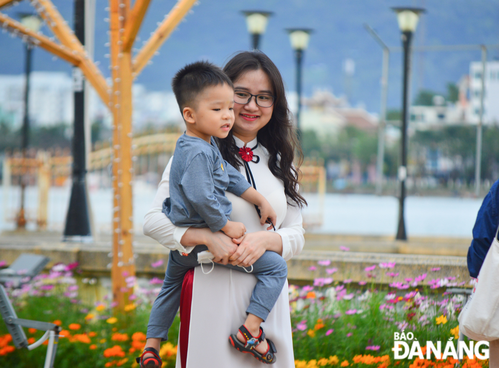 Most of visitors to the Bach Dang flower street strictly practise protective measures against COVID-19, including wearing face coverings. They only are without face coverings as posing for souvenir photos.