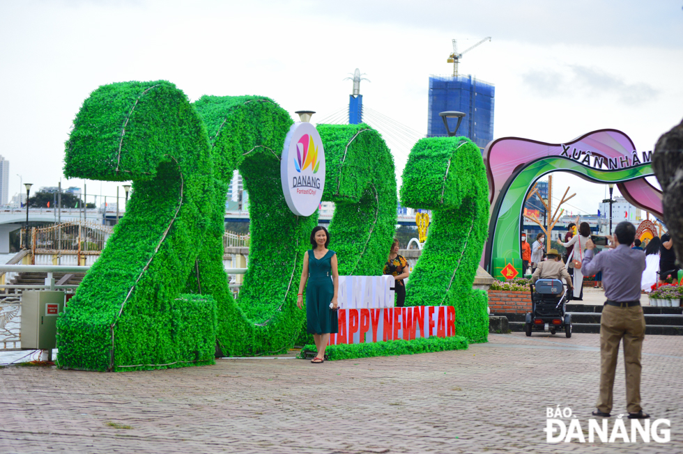 A woman posing for souvenir photos with the 2022 symbol on Bach Dang Street.