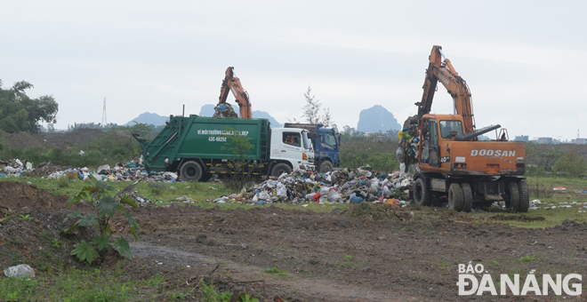 Điểm trung chuyển được thiết lập tại khu đất trống ở cuối tuyến đường Trần Nam Trung (quận Cẩm Lệ) để giải phóng nhanh khối lượng rác tăng cao. Ảnh: HOÀNG HIỆP
