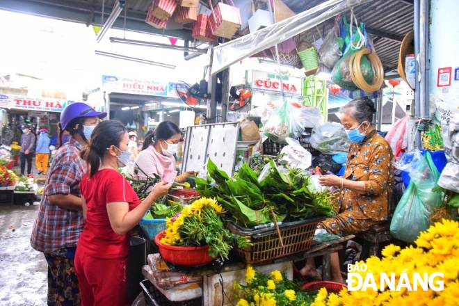 A stall selling fresh areca nuts and betel leaves in the Con Market is filled with people.