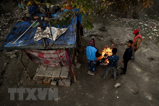 Người vô gia cư đốt lửa sưởi ấm tại New Delhi, Ấn Độ, ngày 29/1/2022. (Ảnh: AFP/TTXVN)