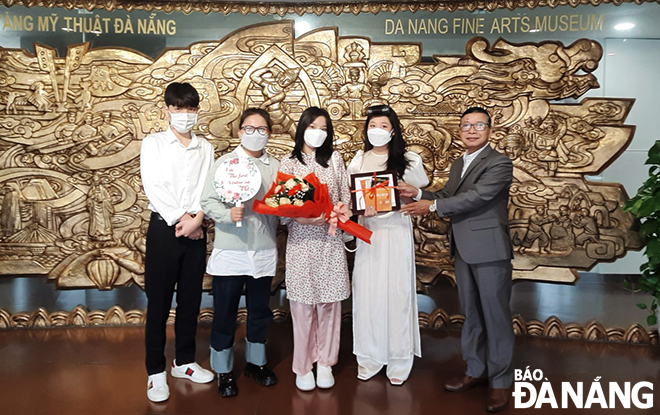 Director of the Da Nang Fine Arts Museum Ha Thanh Van (first right) giving gifts to the first guests to the museum on the first day of Tet.