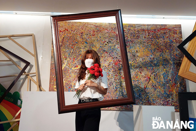 A young girl posing for her souvenir photo at a check-in space at the Da Nang Fine Arts Museum