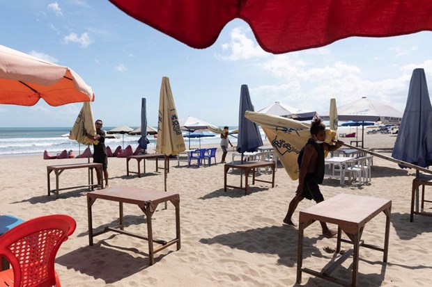 Workers pack up the parasols to close the beach in Seminyak, Bali (Photo: Reuteres)