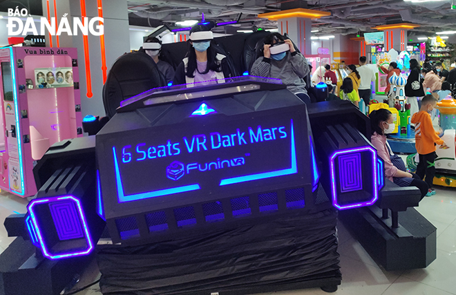 A group of children are seen experiencing virtual reality driving at the amusement area in the Vincom Center Danang.