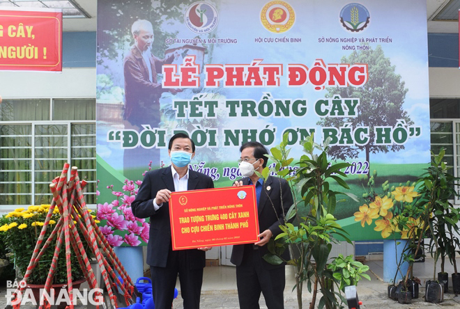 Lãnh đạo Sở Nông nghiệp và Phát triển nông thôn (trái) trao tượng trưng 400 cây giống cho Hội Cựu chiến binh thành phố để trồng đầu xuân Nhâm Dần. Ảnh: HOÀNG HIỆP