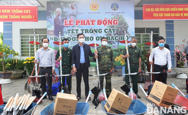 A leader of the Da Nang Department of Natural Resources and Environment (third, left) giving tools in the service of environmental protection and tree planting to the municipal Veterans' Association. Photo: HOANG HIEP