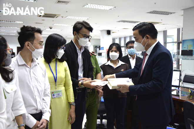 Da Nang People’s Committee Chairman Le Trung Chinh (right) giving lucky money to staff at the 'One-stop-shop' department of the Da Nang Administrative Centre on the first working day after Tet. Photo: TRONG HUY