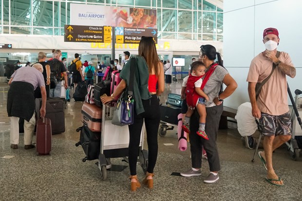 Passengers wait to handle procedures at Ngurah Rai airport of Indonesia. (Photo: AFP/VNA)