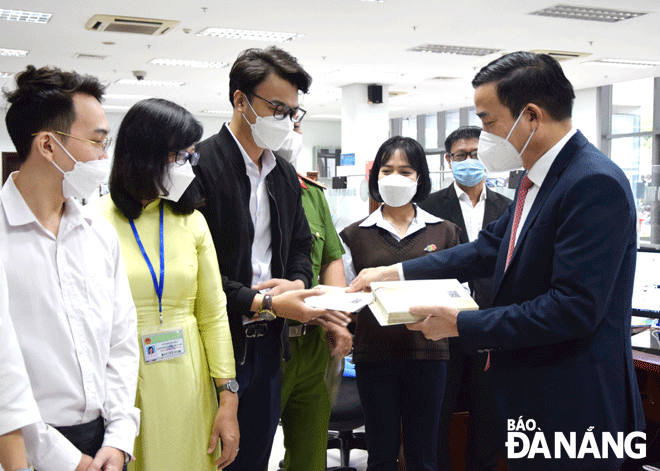 Da Nang People’s Committee Chairman Le Trung Chinh (right) giving lucky money to staff at the 'One-stop-shop' department of the Da Nang Administrative Centre on the first working day after Tet. Photo: TRONG HUY