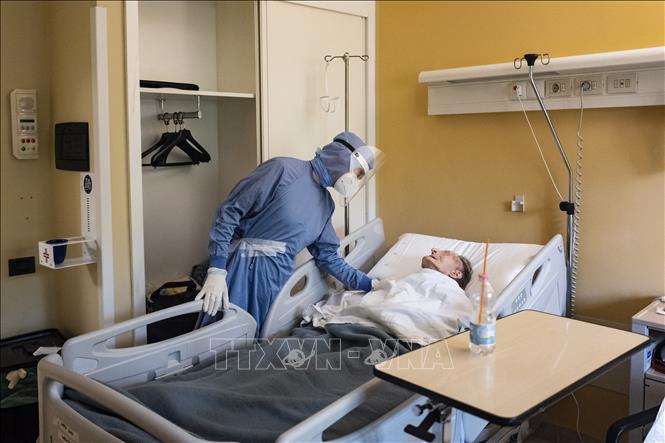 Nhân viên y tế điều trị cho bệnh nhân COVID-19 tại bệnh viện ở Turin, Italy. Ảnh: AFP/ TTXVN