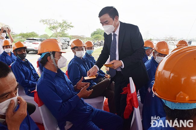 Chủ tịch UBND thành phố Lê Trung Chinh lì xì quà Tết đến người lao động tại dự án Tuyến ống thoát nước dọc tuyến đường 2 Tháng 9. Ảnh TRIỆU TÙNG