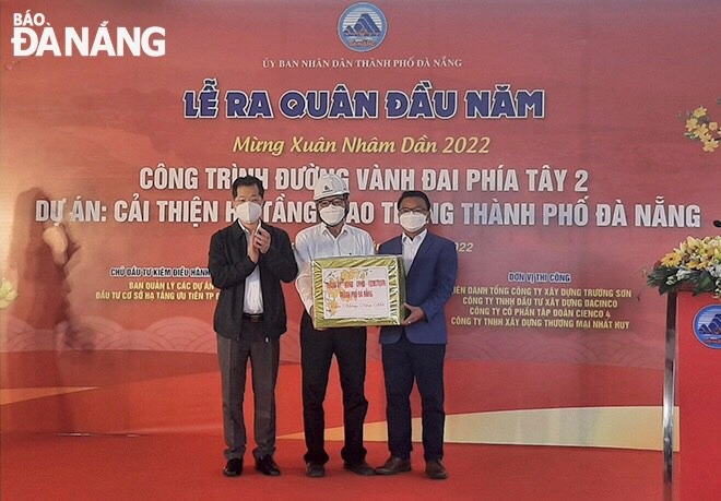 Bí thư Thành ủy Nguyễn Văn Quảng (bìa trái) tặng quà động viên ban quản lý dự án, nhà thầu thi công dự án Đường vành đai phía tây 2. Ảnh: V.HOÀNG