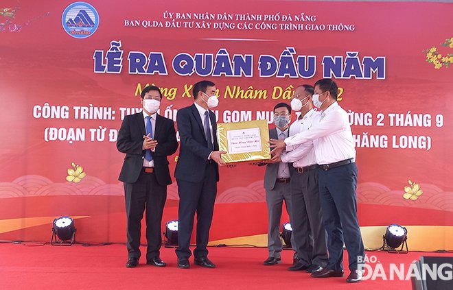 Chủ tịch UBND thành phố Lê Trung Chinh (thứ 2 bên trái sang) tặng quà đến các đơn vị thực hiện dự án 