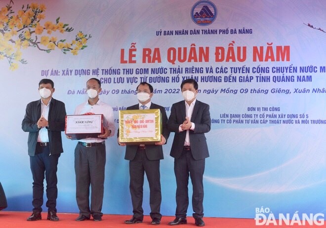 Deputy Secretary Triet (first right), and Standing Vice Chairman Minh (first left) presenting Tet gifts the management board and construction units of the separate wastewater collection system and sewer line project. Photo: HOANG HIEP