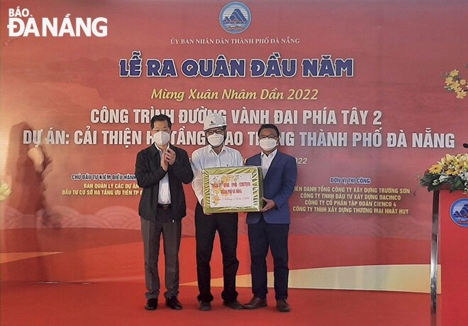 Secretary Quang (left) giving an encouragement gift to the management board of the West Ring Road 2 project. Photo: V. HOANG 