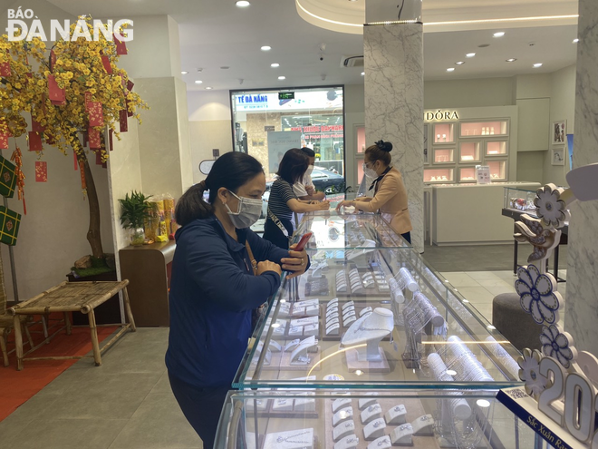 Customers refer to gold prices at the PNJ Store 70 Tran Phu in Hai Chau District. Photo: M.QUE