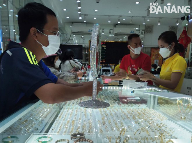 Customers are seen buying gold pieces at a gold shop on Ton Quang Phiet Street in Son Tra District