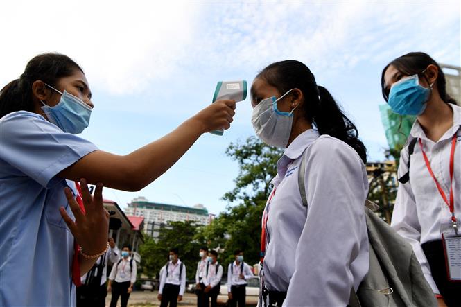 Kiểm tra thân nhiệt phòng dịch Covid-19 tại trường học ở Phnom Penh, Campuchia. Ảnh: AFP/ TTXVN