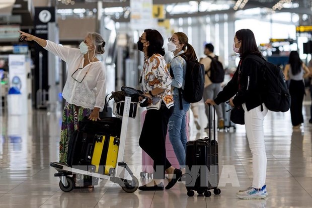 Passengers look at a flight schedule screen at Suvarnabhumi Airport in Bangkok. (Photo: AFP/VNA)