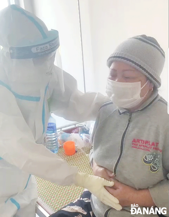 Da Nang sees a growing number of older patients with COVID-19 who have an underlying health condition, thereby putting a great pressure on local health system. IN THE PHOTO: A healthcare professional giving instructions on breathing exercises to a female older patient at the field hospital for COVID-19 patients. Photo: PHAN CHUNG