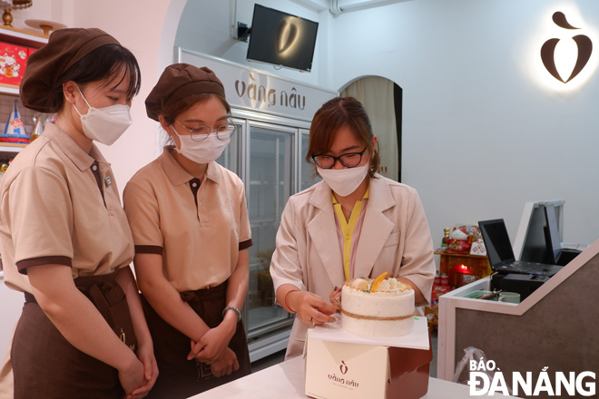 Nguyen Mai Hue Man (first, right) instructs Vang Nau staff how to decorate cakes. Photo: MAI HIEN