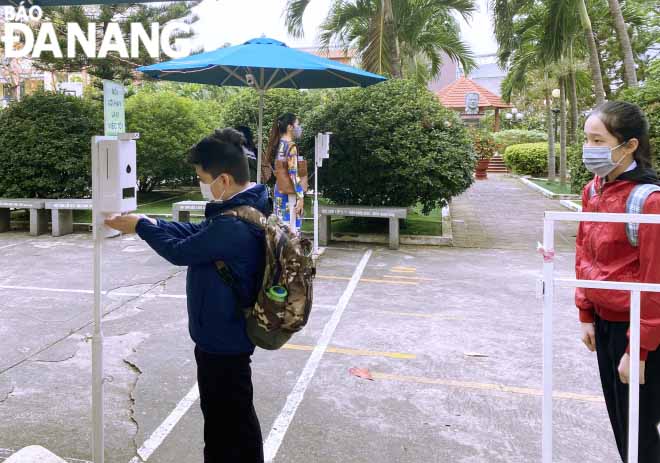 Sixth graders at the Le Do Junior High School located in Son Tra District disinfect their hands before entering the class. Photo: NGOC HA.