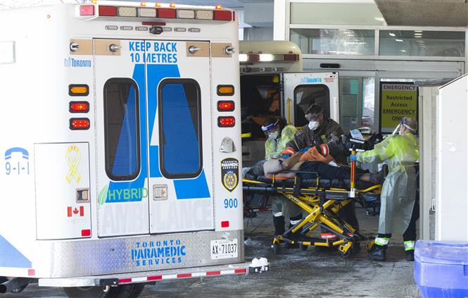 Nhân viên y tế chuyển bệnh nhân Covid-19 tới bệnh viện tại Toronto, Canada, ngày 28-1-2022. Ảnh: THX/ TTXVN
