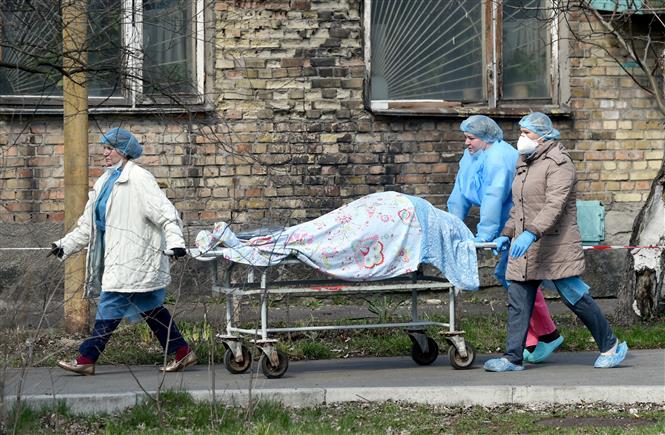 Nhân viên y tế chuyển thi thể bệnh nhân COVID-19 tới nhà xác ở Kiev, Ukraine ngày 9/4/2021. Ảnh: AFP/TTXVN