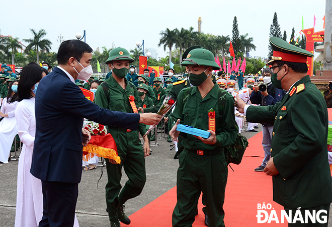 Chủ tịch UBND thành phố Lê Trung Chinh tặng hoa và động viên các tân binh lên đường làm nhiệm vụ. Ảnh: XUÂN DŨNG