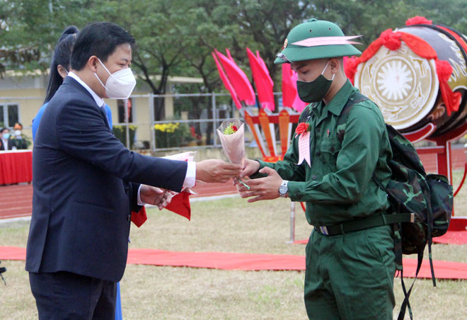 Phó Bí thư Thường trực Thành ủy Lương Nguyễn Minh Triết (trái) tặng hoa, động viên và chúc mừng các chiến sĩ tham gia nghĩa vụ công an nhân dân. Ảnh: PHAN CHUNG