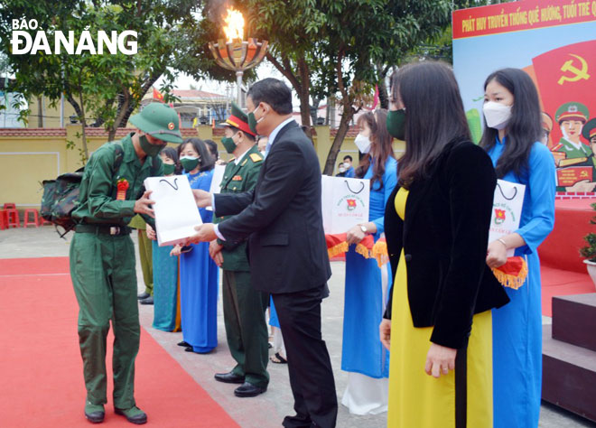 Phó Chủ tịch UBND thành phố Hồ Kỳ Minh tặng quà cho thanh niên nhập ngũ ở quận Cẩm Lệ. Ảnh: LÊ VĂN THƠM