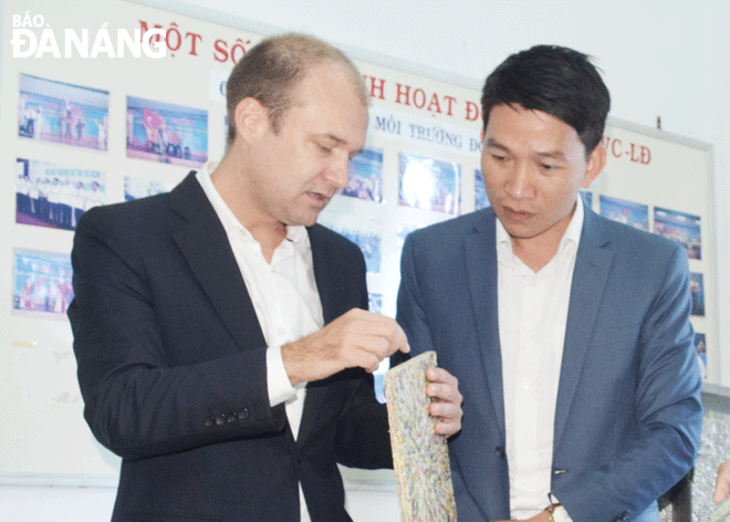 Ông Bùi Trung Khánh (bên phải) trao đổi với chuyên gia nước ngoài về hệ thống tái chế rác tại bãi rác Khánh Sơn thành những sản phẩm dân dụng. (Ảnh chụp khi không có Covid-19) Ảnh: NAM TRÂN