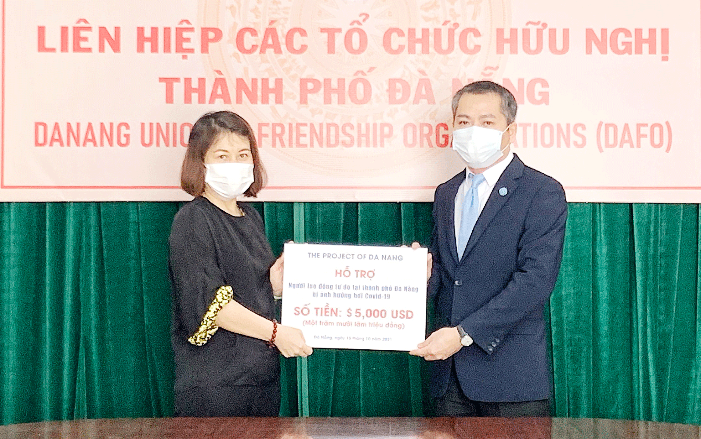 Chủ tịch Liên hiệp các tổ chức hữu nghị thành phố Nguyễn Ngọc Bình (bên phải) tiếp nhận hỗ trợ từ Dự án Đà Nẵng của Mỹ để trao cho người lao động tự do và người có thu nhập thấp trên địa bàn thành phố bị ảnh hưởng Covid-19.  (Ảnh do Liên hiệp các tổ chức hữu nghị thành phố cung cấp)