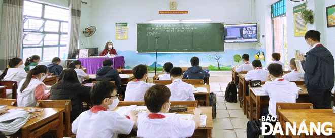 The Le Do Junior High School located in Son Tra District is seeing their teachers running classes where some students are attending in person, and at the same time, the quarantined ones are joining the live class from home via video conferencing. Photo: NGOC HA