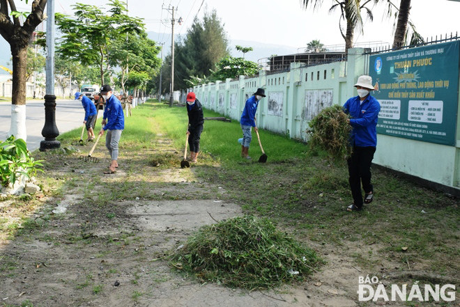 Các đoàn viên thanh niên của một doanh nghiệp ở Khu công nghiệp dịch vụ thủy sản Đà Nẵng ra quân tổng vệ sinh môi trường. Ảnh: HOÀNG HIỆP