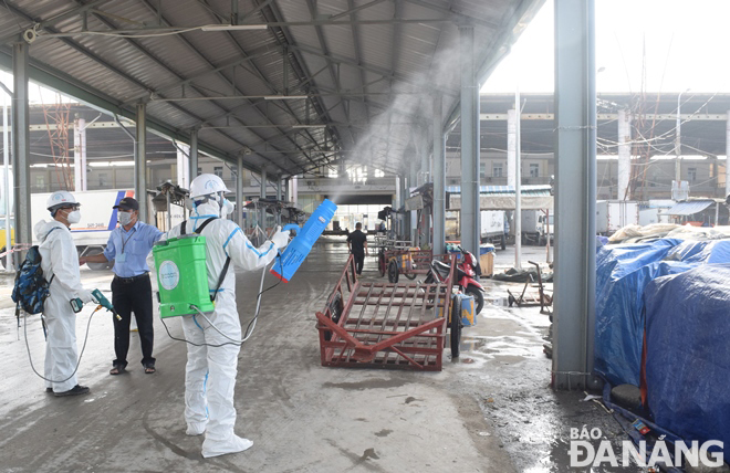 The Centre for Environmental Engineering and Chemical Safety (CENTEC) staff spray disinfectant at Tho Quang fishing wharf Photo: HOANG HIEP